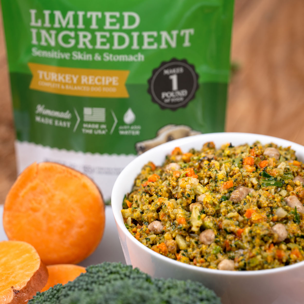 Limited Ingredient Turkey Recipe dog food in a bowl with sweet potato and broccoli beside green USA bag