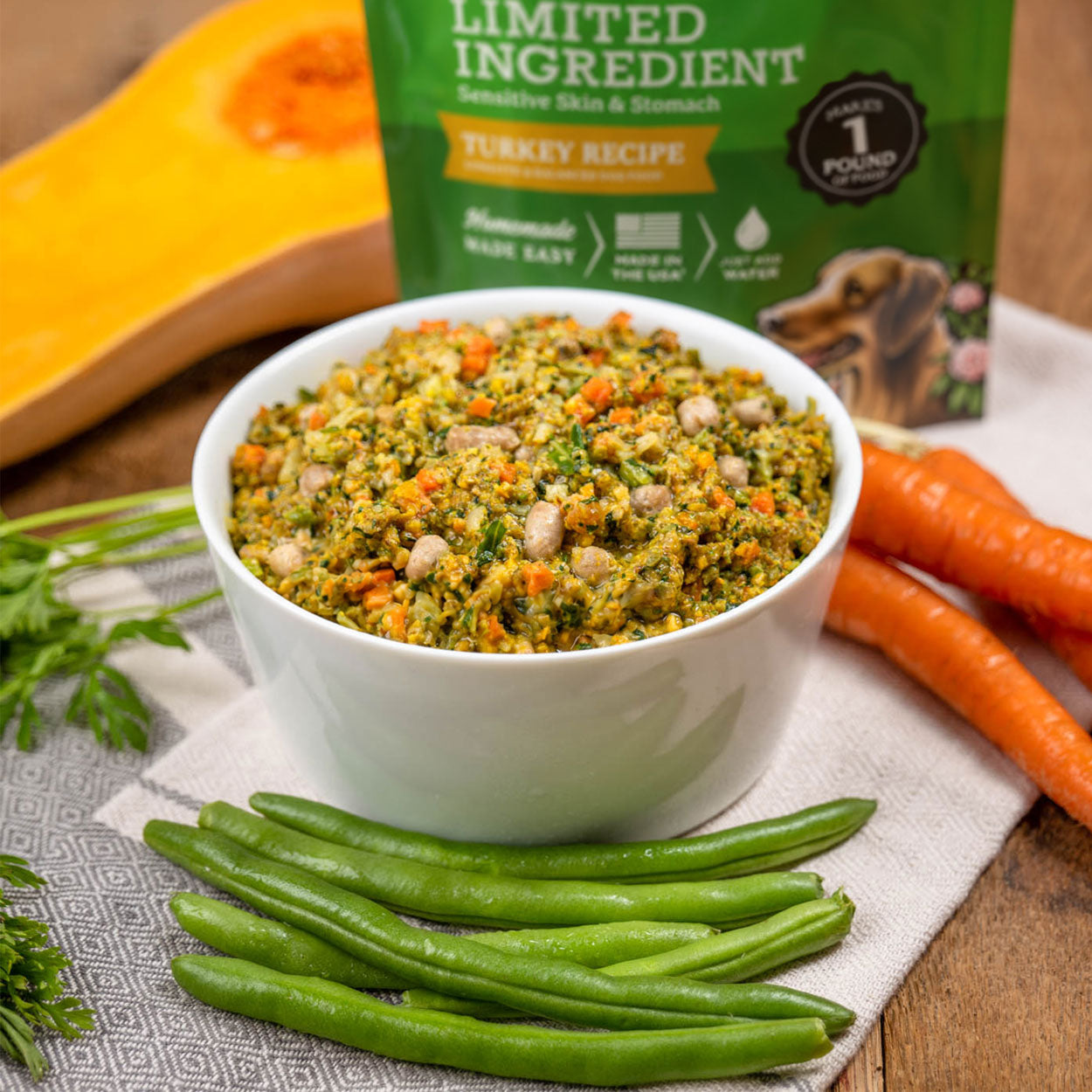 Bowl of Gather Free Acres Turkey Recipe wet dog food surrounded by fresh carrots, green beans, and butternut squash